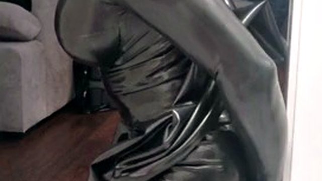 Rubber latex sissy in gas mask plays with a dildo