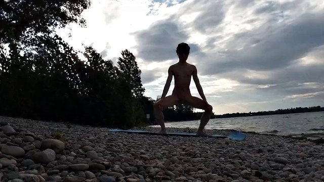 Slim nudist boy doing yoga naked on a nudist beach. Nude yoga video by John Artin, gay porn model, skinny naturist, twink, practice